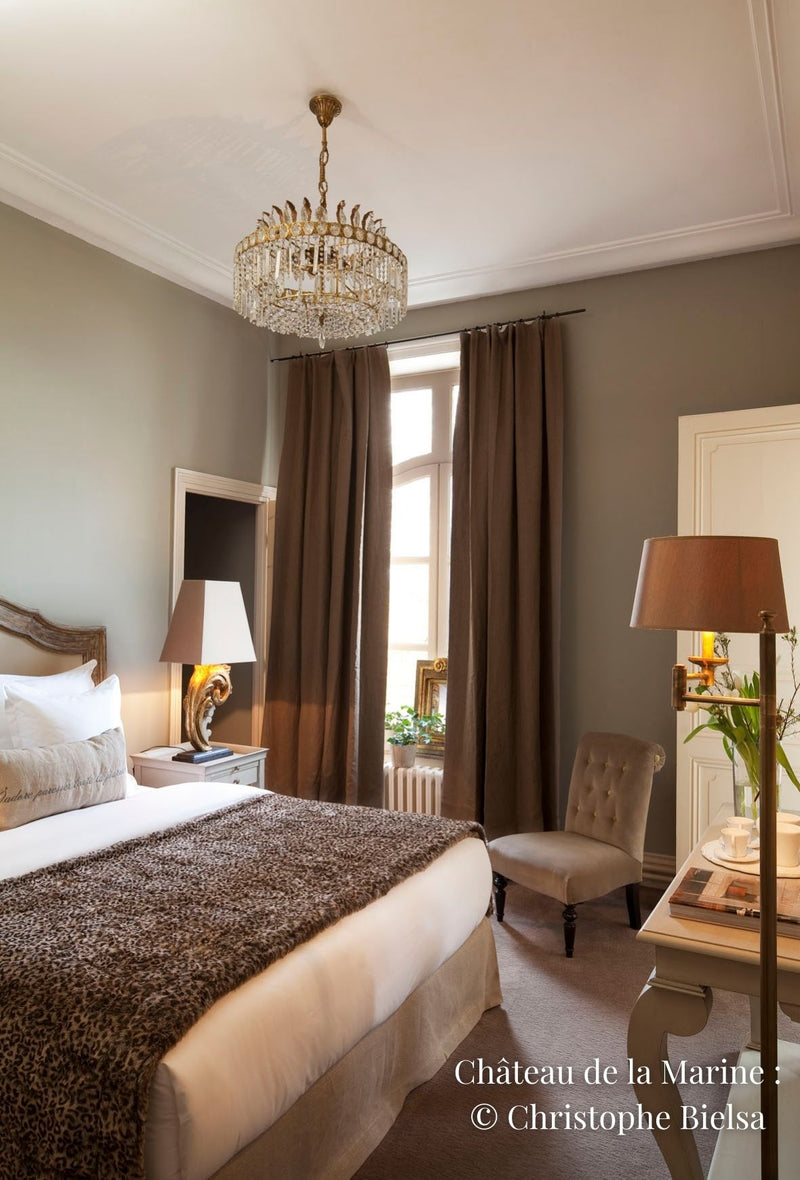 Chambre à coucher de château avec un lit, luminaires et fauteuil
