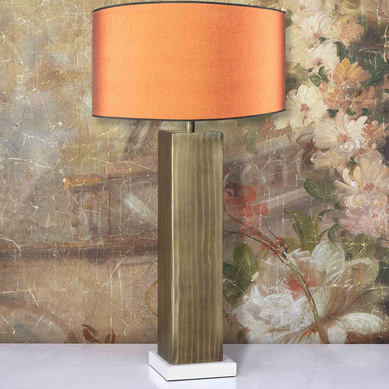 Maillot carrée Lampe en laiton doré abat-jour orange posée sur table